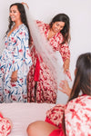 Bride and bridesmaid getting ready in red floral robes