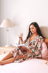 Maxi Pink Lotus robe lounging on bed drinking tea and reading book